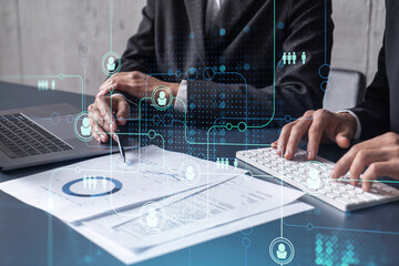 Two HR specialists man and woman analyzing the market of alumni to boost the intern program at international consulting company. Hiring new talented officers. Social media hologram icons.