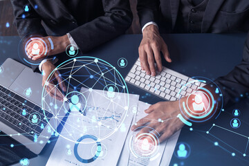 Two HR specialists man and woman analyzing the market of alumni to boost the intern program at international consulting company. Hiring new talented officers. Social media hologram icons.