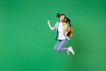 Full length happy young woman student in shirt backpack hold notebooks jumping doing winner gesture...