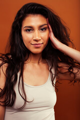 Fototapeta premium young pretty girl with curly hair posing cheerful on brown background, lifestyle people concept