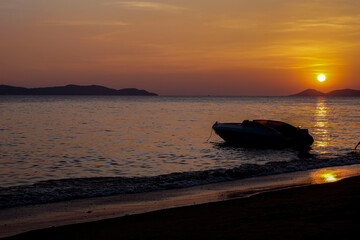 The boat in the sea and the sun is setting