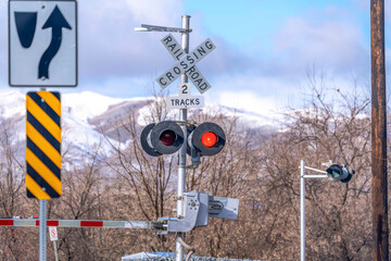 Grade crossing signal with red light gate and crossbuck at railroad crossing