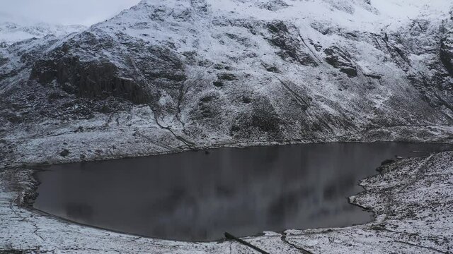 Llyn Idwal and the Snowdonia Glyderau mountains in winter aerial shot
