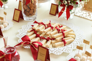 Wafers tied with a red ribbon on a wedding sweet table