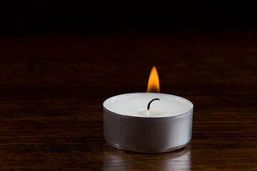 Obraz na płótnie Canvas burning tealight candle in the dark