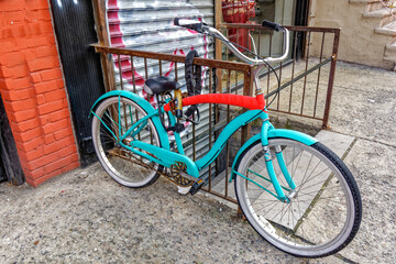 Blue and red bicycle attached to a ramp that leads to a basement of a commercial building in New...