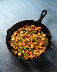 Vegetarian meat free mycoprotein pieces vegetable stir fry served in cast iron skillet frying pan