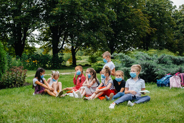 A class of masked school children is engaged in outdoor training during the epidemic. Back to school, learning during the pandemic