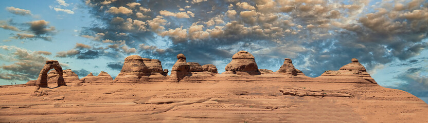 Fototapeta na wymiar Delicate Arch panoramic view, Arches National Park. High resolution image of rock formations against blue sky