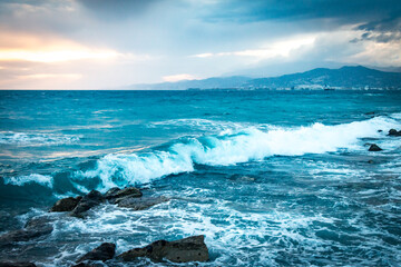 waves on the beach at sunset, thunderstorm approaching