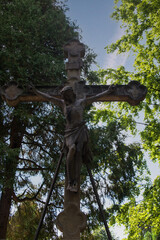 großes Kreuz mit Jesus vor einer dunklen Tanne