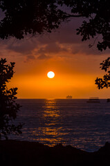 Tropical orange sky sunset over the ocean in the islands o Hawaii.