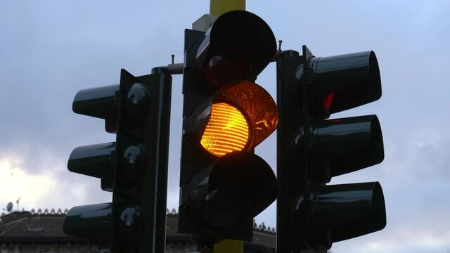 Traffic light with a green, yellow, and red color sequence in the downtown of the city.