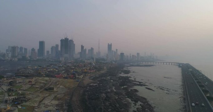 A drone shot at Bandra Worli Sea Link seen from an aerial view in slow motion. Cinematic drone movement with the iconic Mumbai Sea Link at the forefront and the city view in the background.