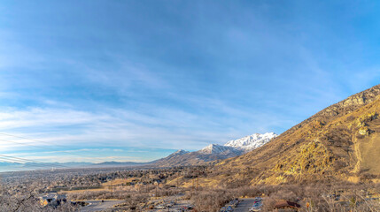 Aerial view of mountain landscape with snowy peak in winter against blue sky