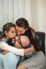 Father joins in the sofa with the family and start tickling everybody. Young carefree parents and...