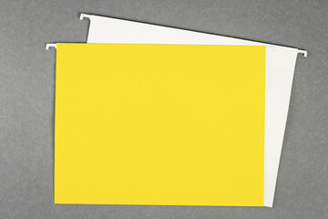 White and yellow hanging files lay flat on gray background. Banner with copy space and mockups for...