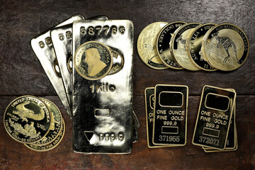gold ingots an various bullion coins on wooden background