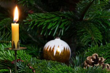 Weihnachtsschmuck und Kerzen aus Bienenwachs am Weihnachtsbaum.