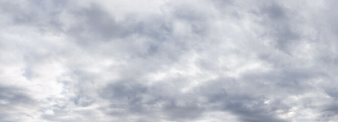Panorama of the sky covered with solid gray clouds