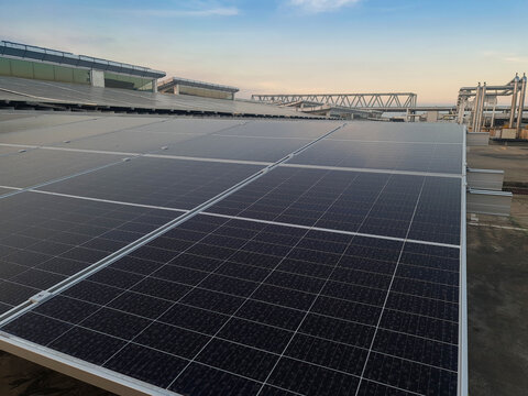 Solar panels plant installation on outdoors roof factory with blue sky on background. Solar panel on the roof.