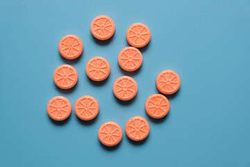 vitamin C pills on a blue background.