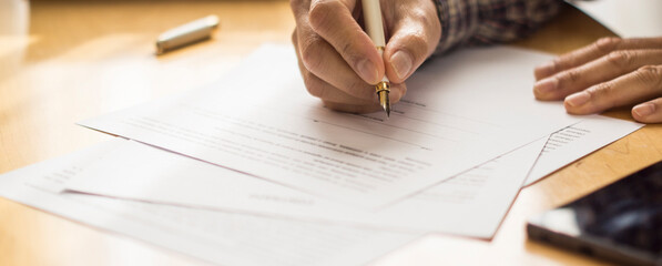 Hand of a man signing papers. Signature. Write