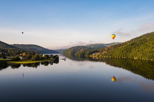 Hot air balloon floating in the morning light over Slapy dam