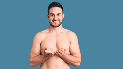 Young handsome man wearing swimwear smiling with hands palms together receiving or giving gesture. hold and protection