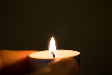 Holding lit tealight candle