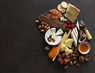Obraz na płótnie Canvas Appetizers platter with various of cheese, curred meat, sausage, olives, nuts and fruits. Festive family or party snack concept. Overhead view.