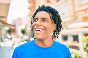 Young african american man smiling happy looking to the side at street of city.