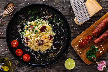 Risotto with parmesan and chorizo on wooden background
