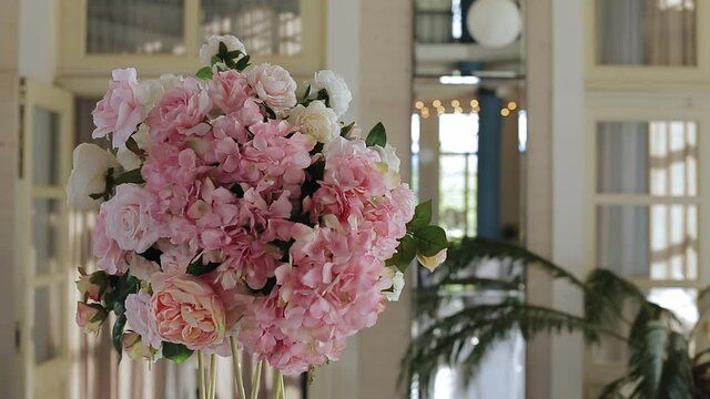 Fresh flowers stand on the table and decorate the room at the event. Taking a close-up of an obj
