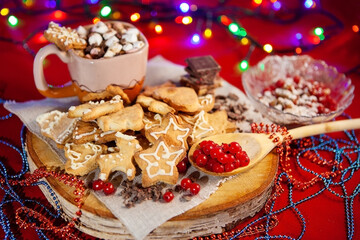 Christmas gingerbread cookies, a cup of hot chocolate in the back.