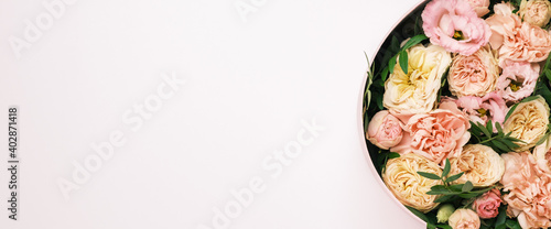 Luxury beautiful flowers in a hat round box on the pink background with copy space. Gift or present on St. Valentines Day, 8 March, Mother Day, wedding