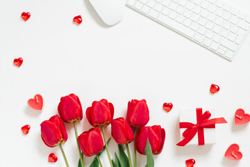 Flat lay Valentines Day background with computer keyboard, gift, coffee mug and red tulip top view white copy space