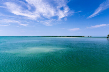 Fototapeta premium View on Varadero in Cuba from a boat at sea, or rather ocean, the sky is blue, the water is turquoise and there are some smooth waves.