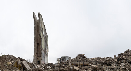 Panorama. The wall of the building with a pile of gray concrete debris and construction debris.