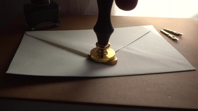Slow-motion of stamping wax for sealing a secure letter. Concept of secret conversation sends in the past. The 18th-century technique of mailing. Medieval way to send encrypted secured messages.