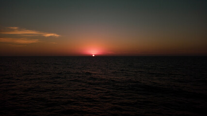 Atardecer y sus bellos colores en medio del Océano Pacífico, mostrando el momento exacto en el que el Sol se esconde por el horizonte.