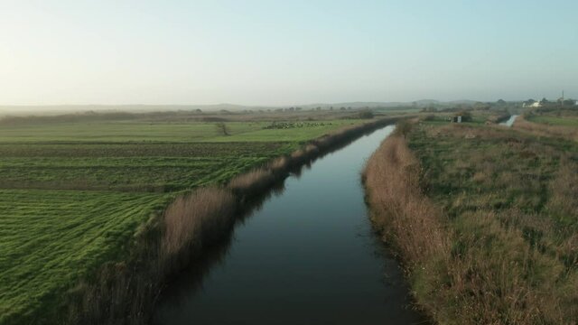 Calm River Water Between Fields In Autumn. Alcobaca River In Nazare, Portugal - wide drone shot