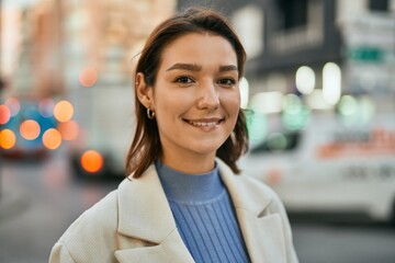 Obraz premium Young hispanic woman smiling happy standing at the city