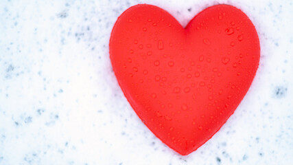 red heart with water drops on the snow