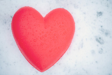 red heart with water drops on the snow
