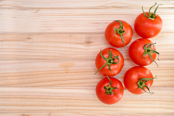 red tomatoes on a wooden table top view.