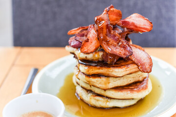Pancakes and syrup with crispy bacon for breakfast