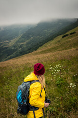 Woman hiking in mountains. Female hiker with camera looking for composition in nature