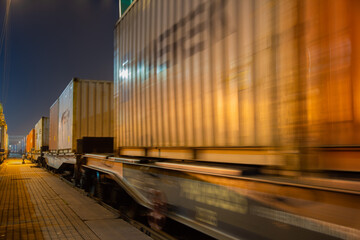 Container train starts moving by rail at night