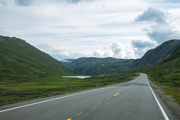 Fototapeta premium Street through a landscape with mountains in Norway